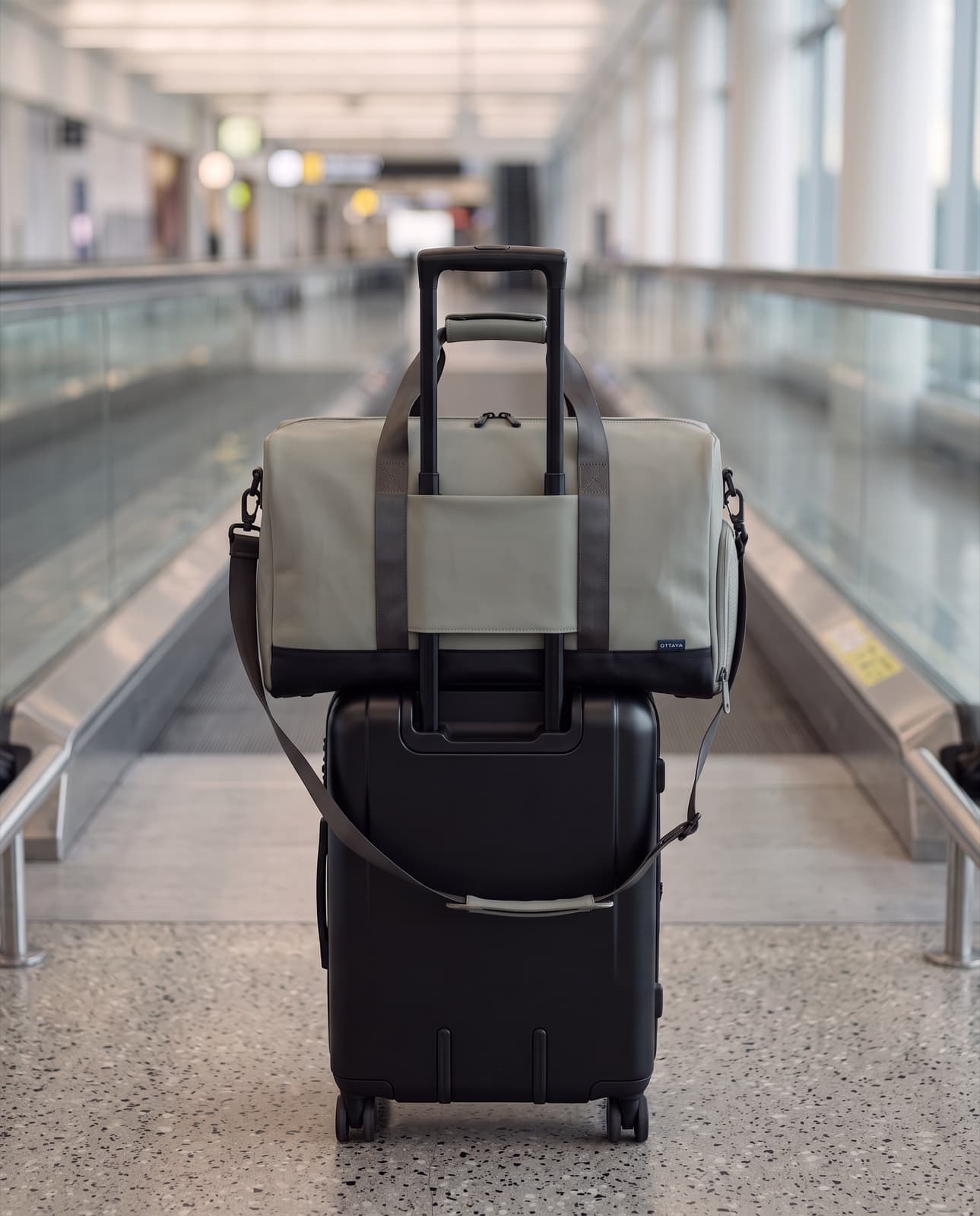Duffel 40 seated on a carry-on in an airport walkway